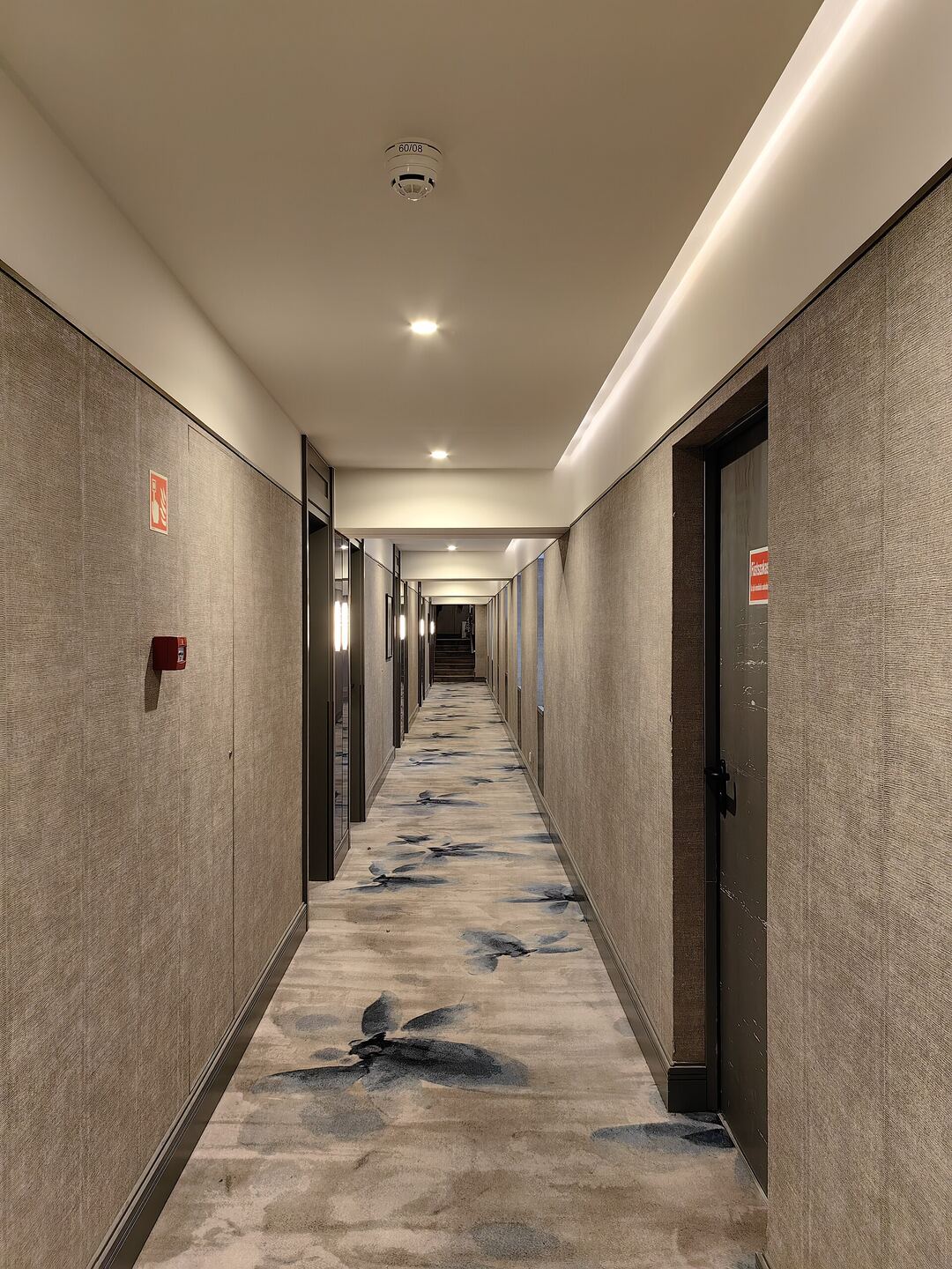 Boutique hotel corridor with dark doors and fabric wall panels